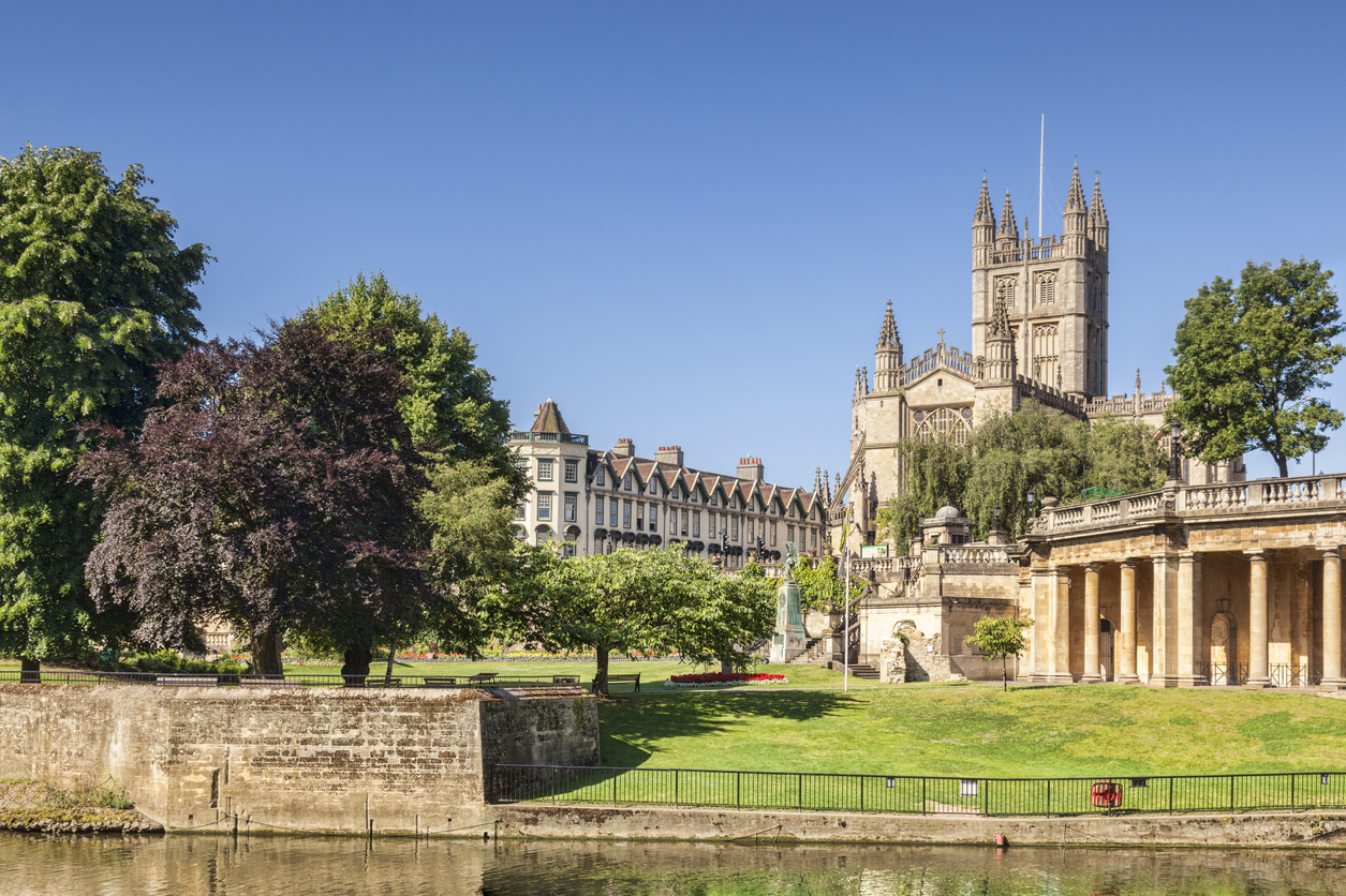 Bath Abbey and the Orangerie on the banks of the River Avon, on a beautiful summer morning with perfectly clear blue sky. Bath, Somerset, England, UK