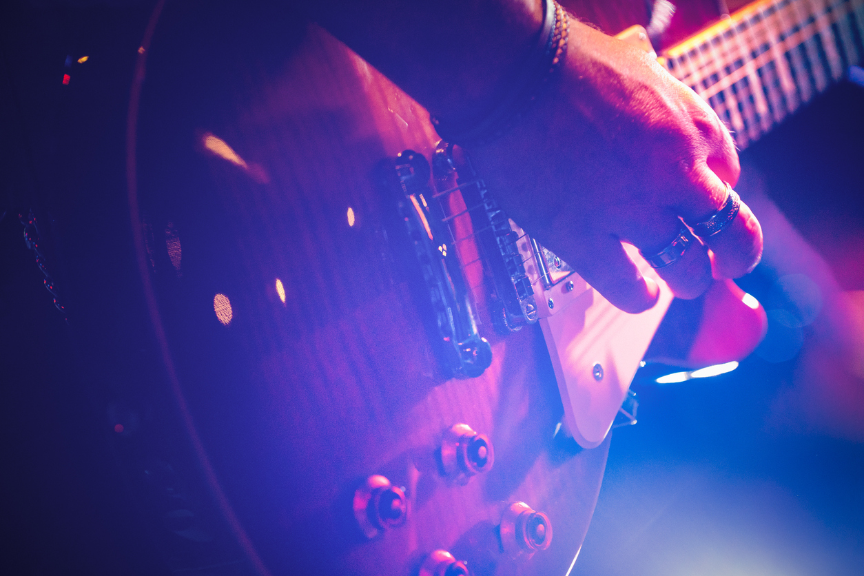 Close up of man playing a guitar at a jazz event in Somerset